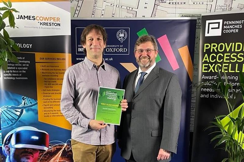 Alexander and Matt Perkins from OUI standing together holding Alexander's award certificate